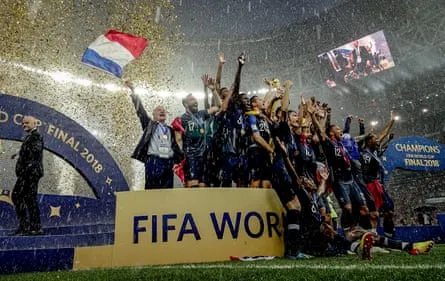 Didier Deschamps waves a flag as Hugo Lloris lifts the trophy after the 2018 World Cup final victory over Croatia