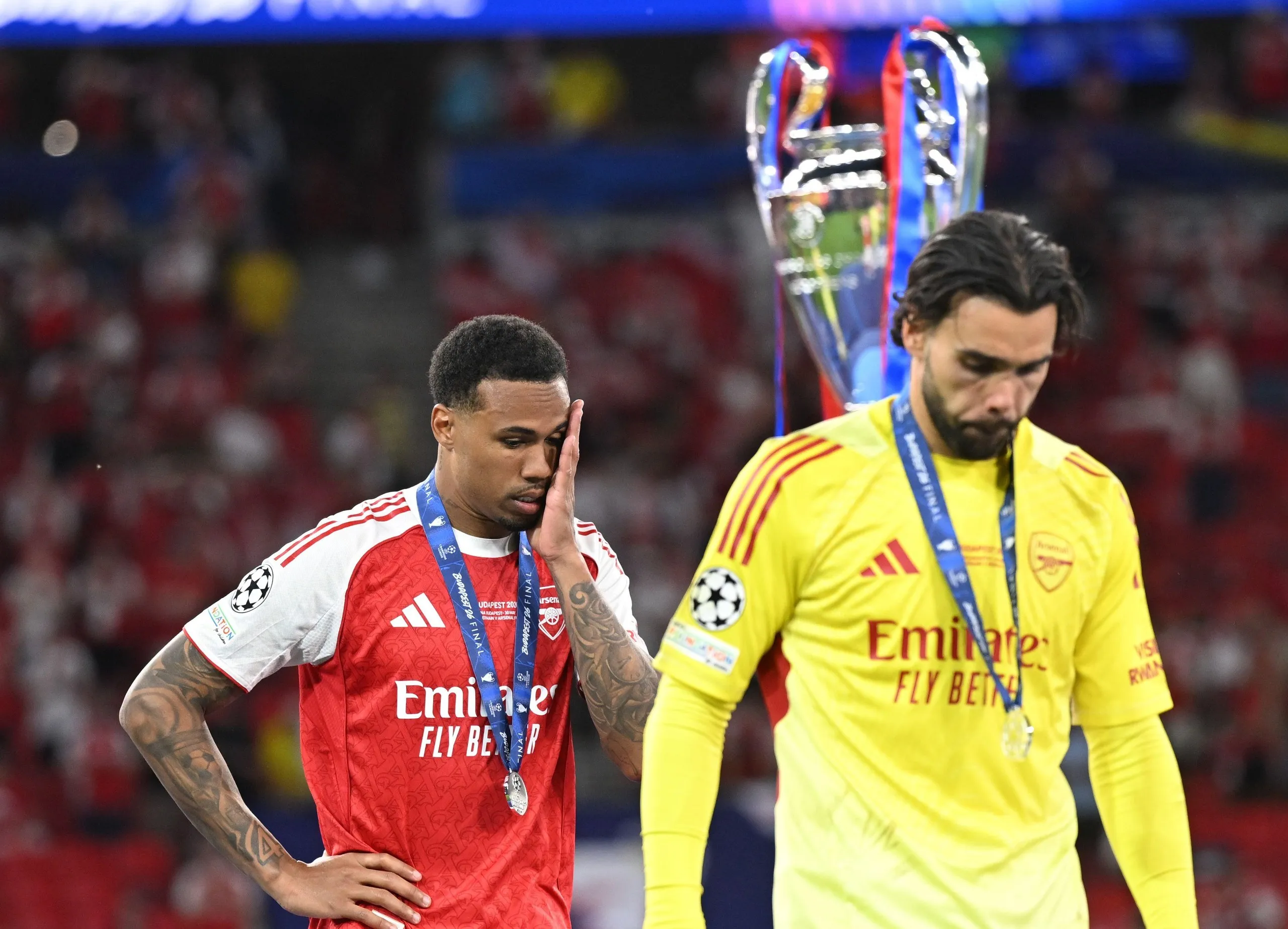 Gabriel Magalhães (left) and David Raya walk past the Champions League trophy after the defeat against Paris St-Germain on penalties