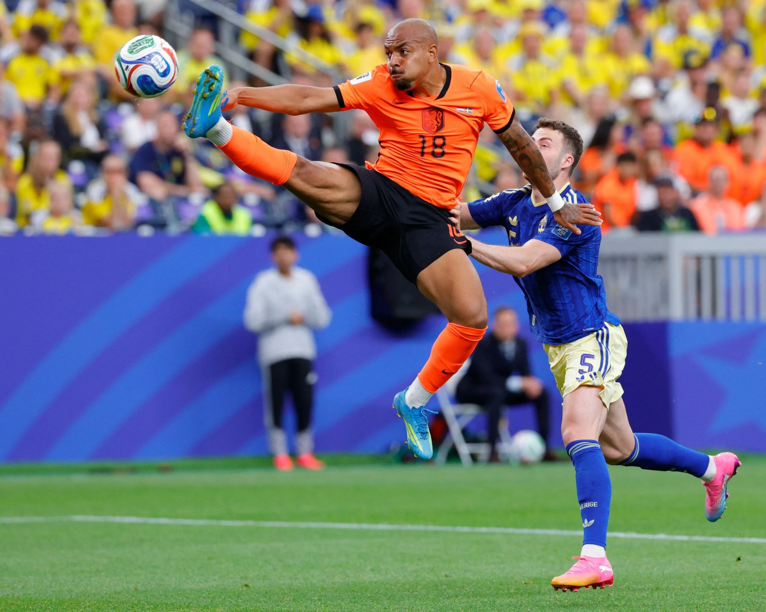 Netherlands midfielder Donyell Malen kicks the ball in front of the goal while Sweden defender Gabriel Gudmundsson defends