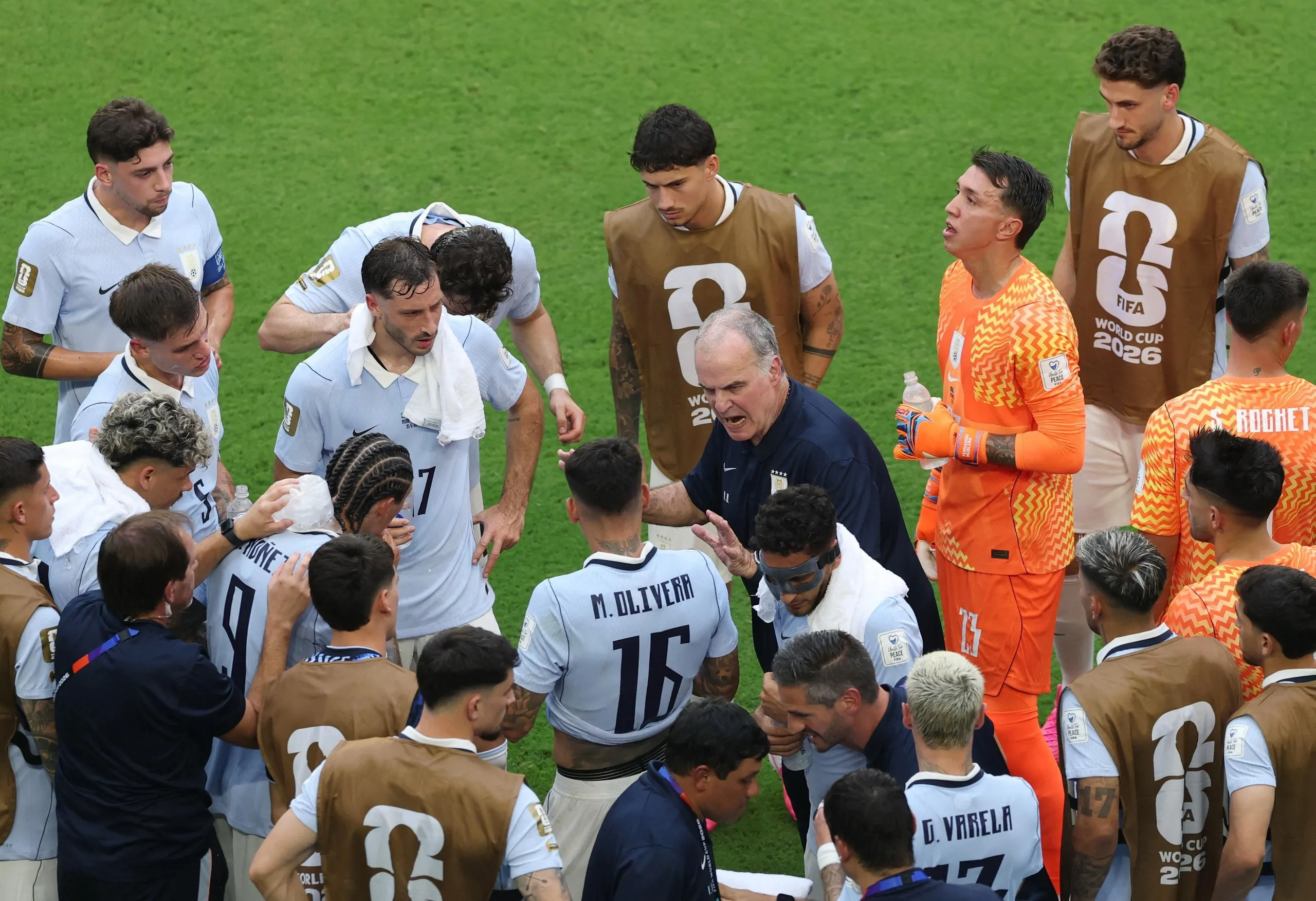 Uruguay coach Marcelo Bielsa speaks to his players during the first half hydration break.