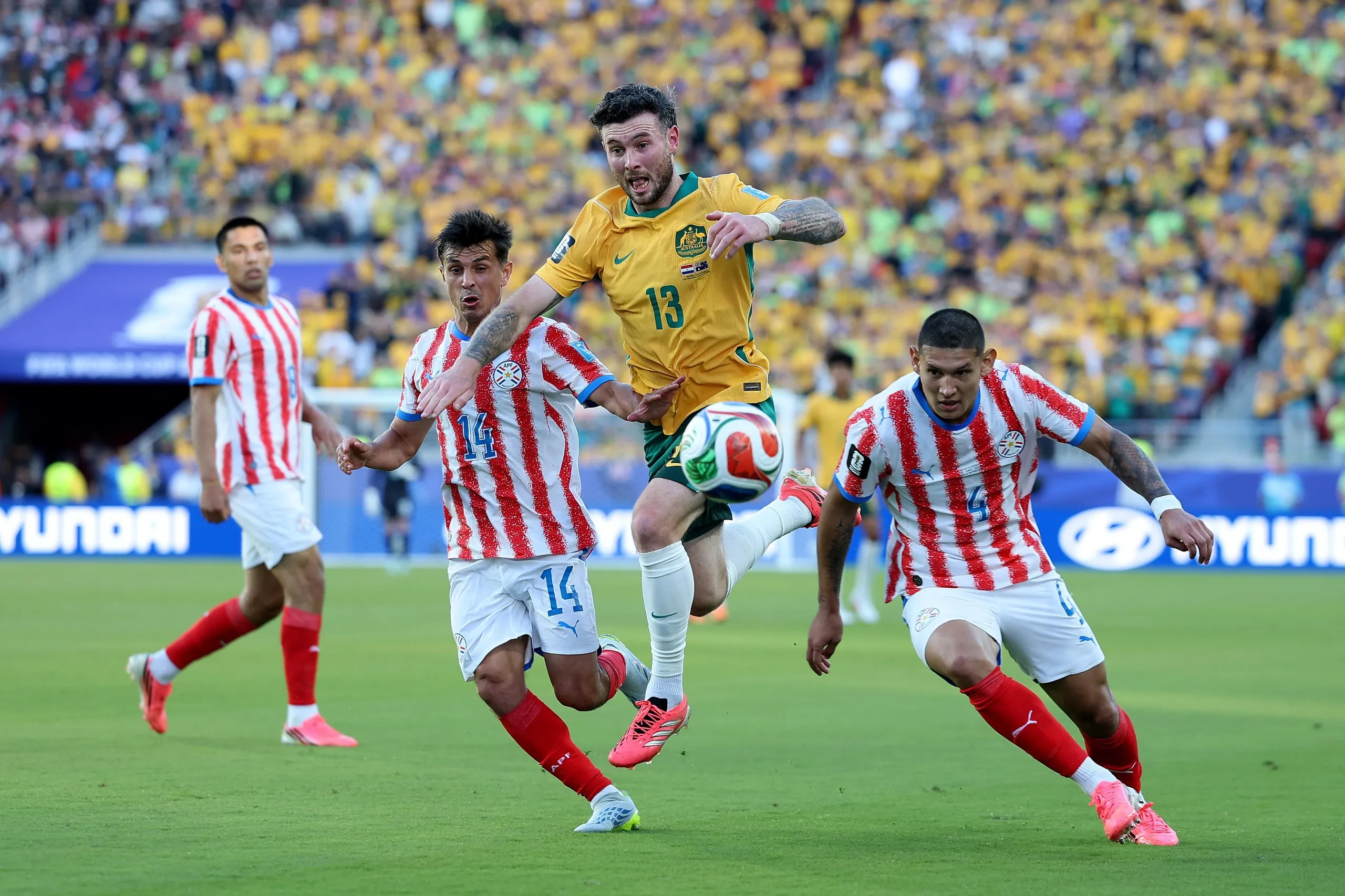 Aiden O'Neill of Australia competes for the ball against Andres Cubas and Juan Jose Caceres