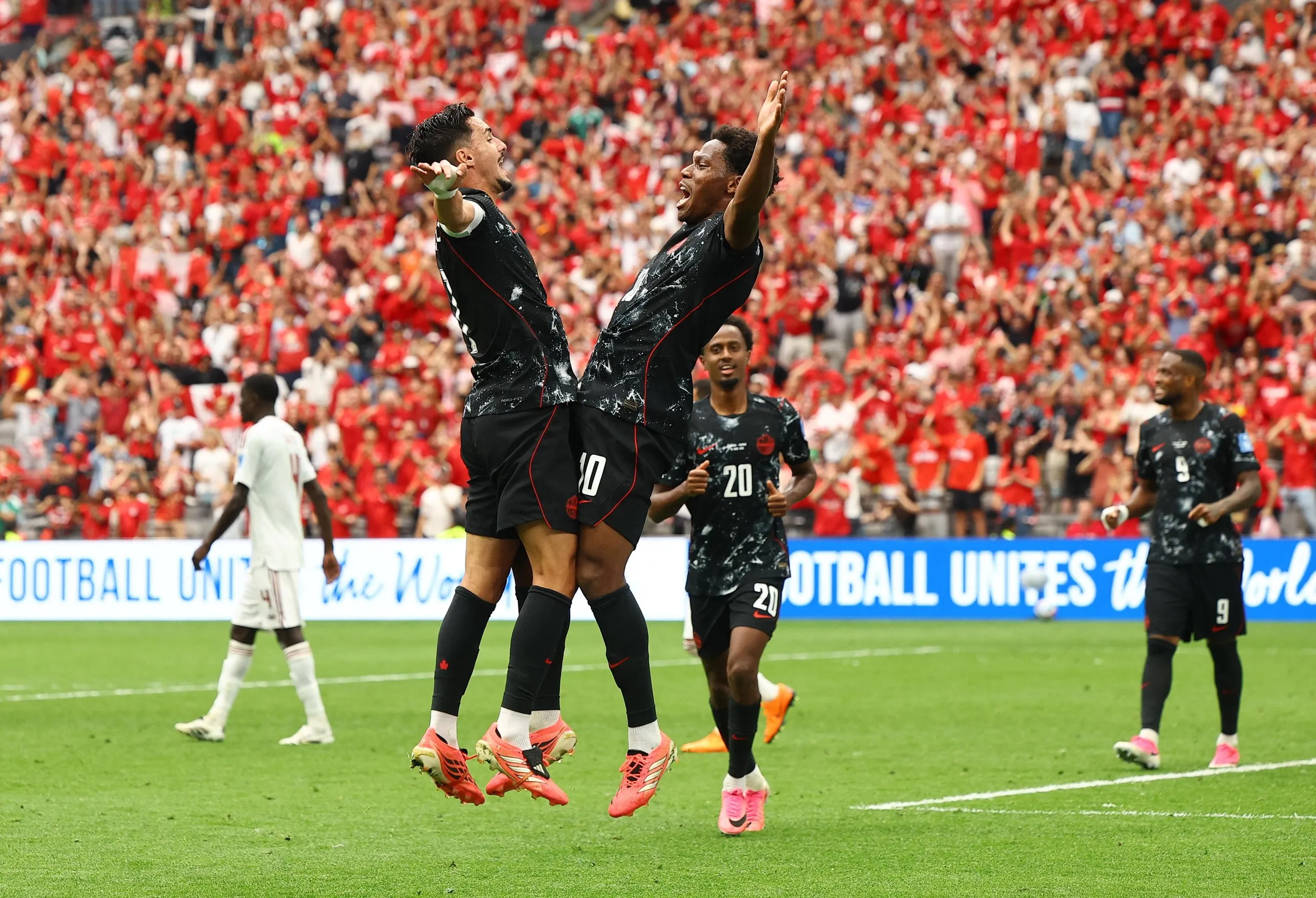 Jonathan David (right) jumps to celebrate his second goal with Stephen Eustáquio.