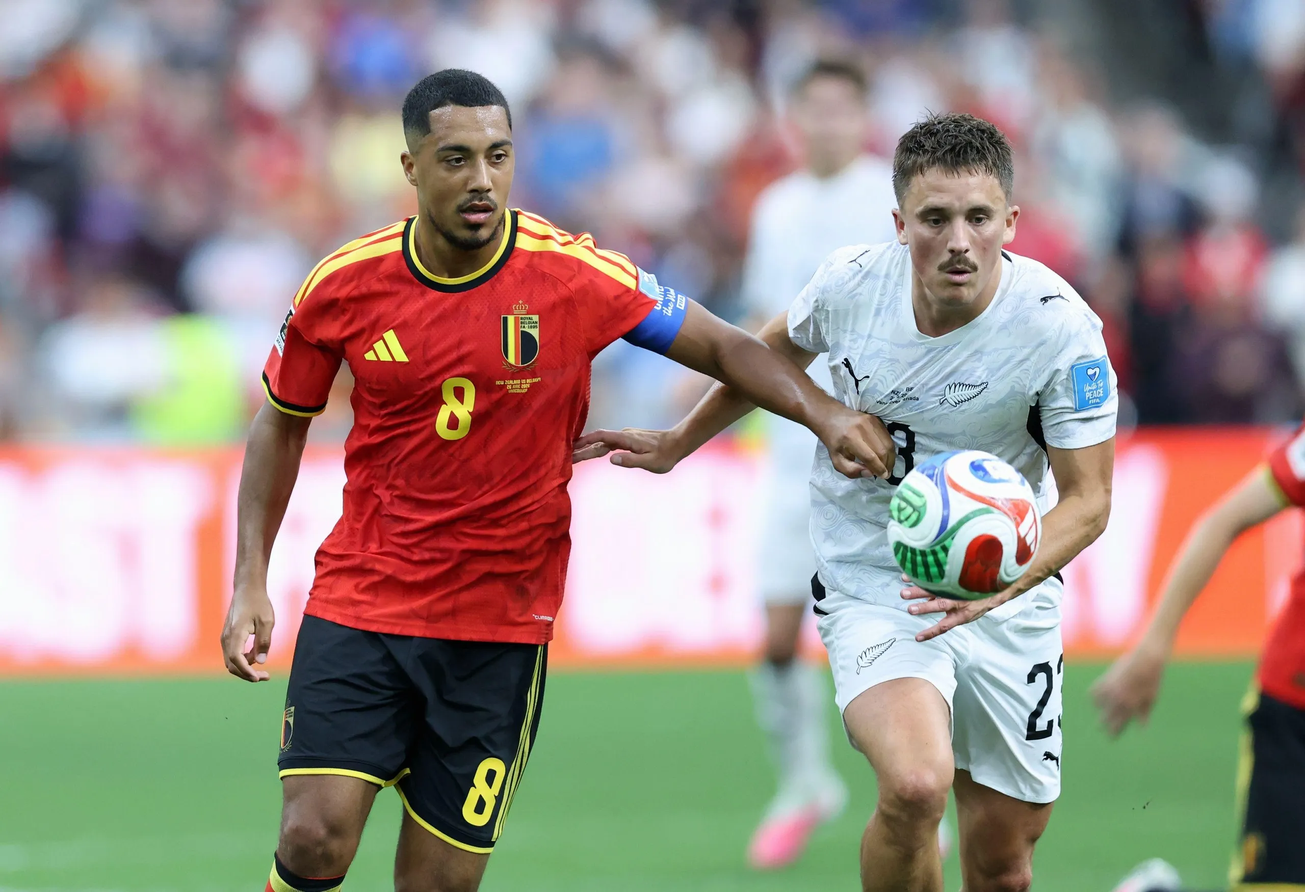 Youri Tielemans holds off New Zealand’s Tim Payne.