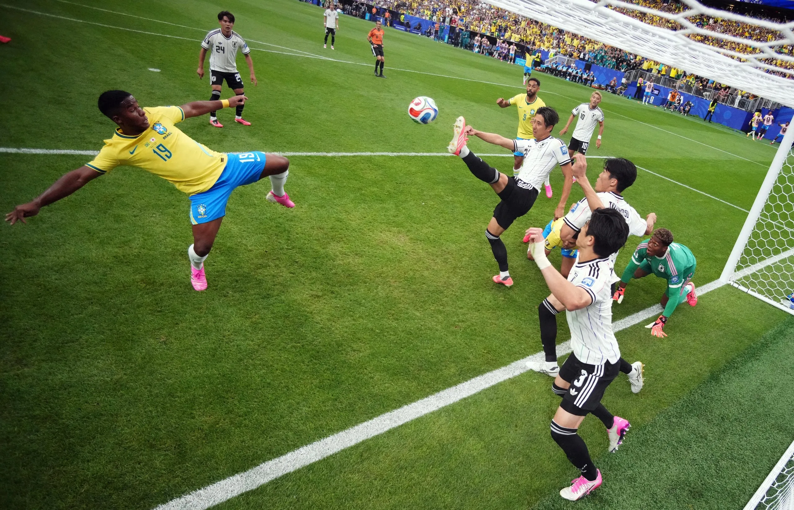 Brazil’s Endrick flings his boot at a loose ball as Japan’s players scramble to clear their lines.