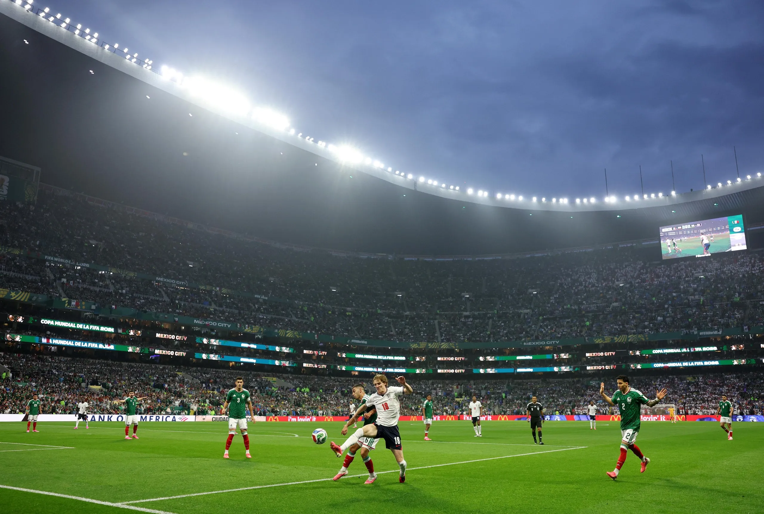 Anthony Gordon competes with Erik Lira as rain falls over the Azteca.